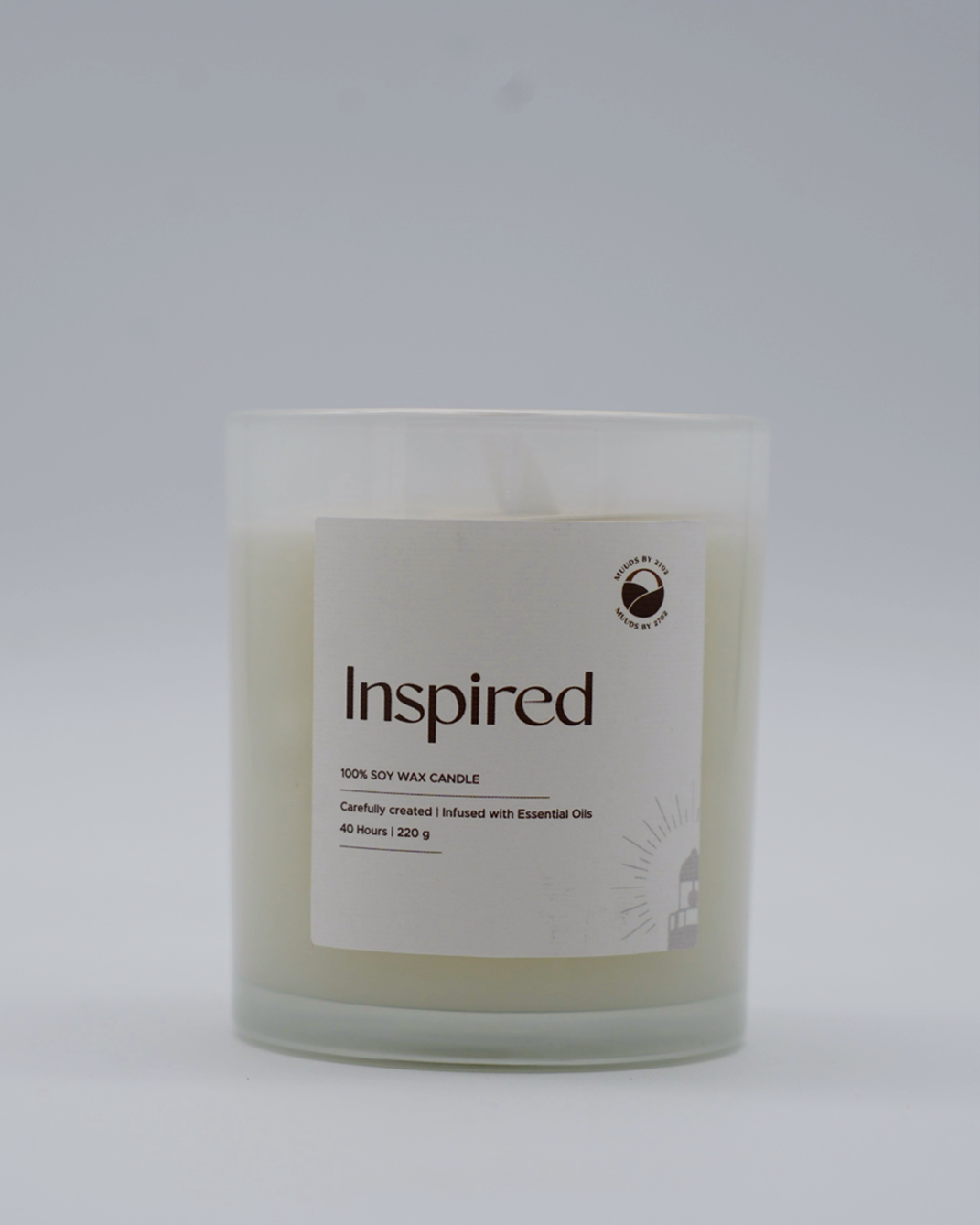 Candle with 'Inspired' label on a white background