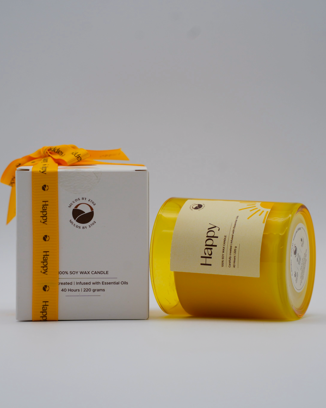 Yellow candle and white box with orange ribbon on a gray background